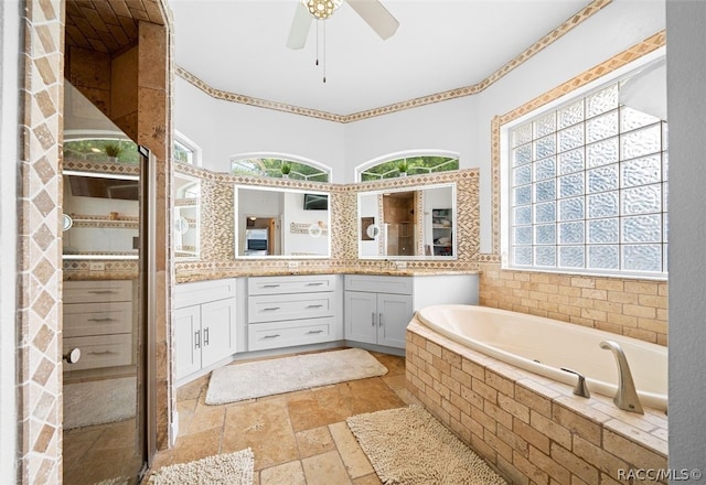 bathroom featuring vanity, ceiling fan, and tiled tub