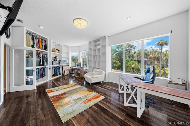 office area with hardwood / wood-style flooring, built in shelves, and a textured ceiling