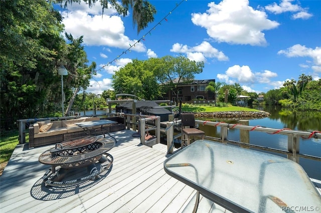 exterior space featuring a water view and a fire pit