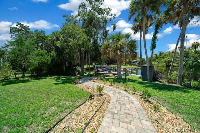 view of property's community featuring a lawn and a water view