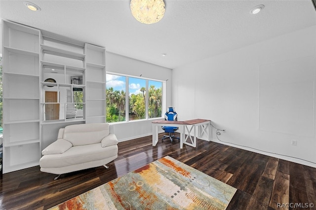 living area with a textured ceiling and dark hardwood / wood-style flooring