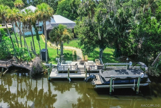 dock area with glass enclosure, a water view, and a yard