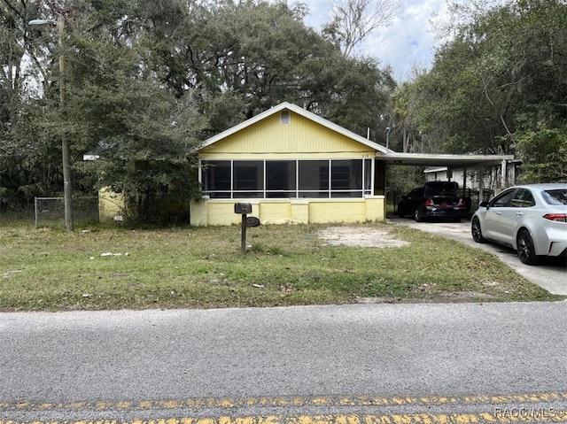 view of front facade featuring a carport, concrete driveway, and a front lawn