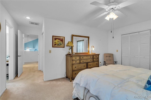 bedroom with a closet, light colored carpet, and ceiling fan