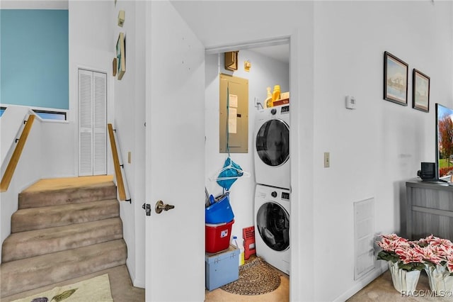 laundry room featuring stacked washing maching and dryer and electric panel