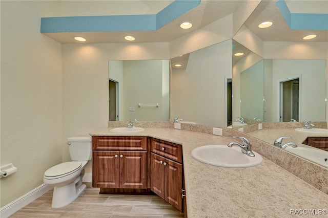 bathroom featuring wood-type flooring, vanity, and toilet