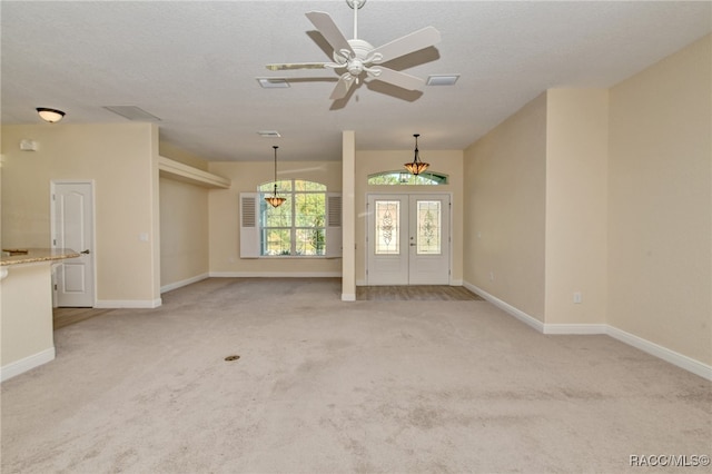 unfurnished living room with french doors, light colored carpet, and ceiling fan