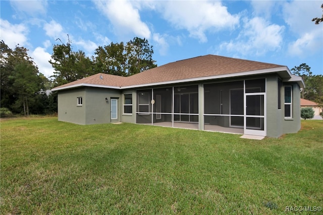 back of property featuring a lawn and a sunroom