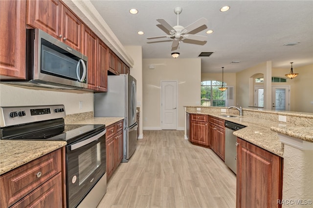 kitchen featuring ceiling fan, light stone countertops, light wood-type flooring, decorative light fixtures, and stainless steel appliances