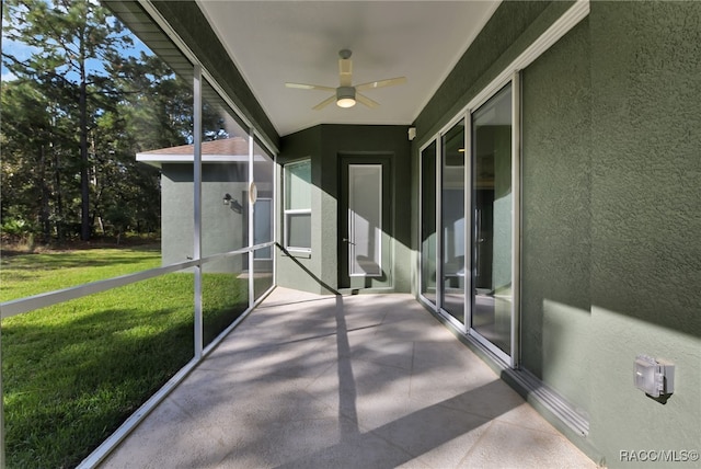 unfurnished sunroom featuring ceiling fan