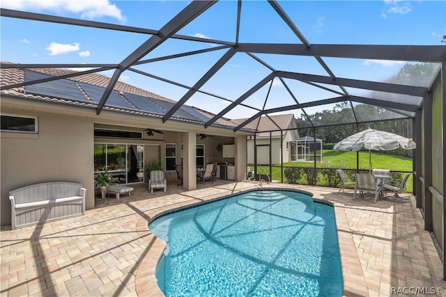 view of swimming pool featuring ceiling fan, a lanai, and a patio