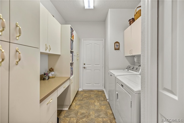 clothes washing area with washer and clothes dryer, cabinets, and a textured ceiling