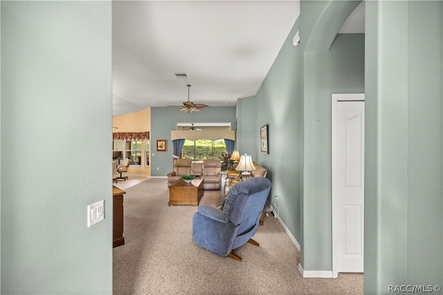 carpeted living room with ceiling fan and vaulted ceiling