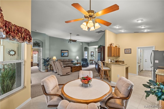 dining area with light colored carpet, vaulted ceiling, and ceiling fan