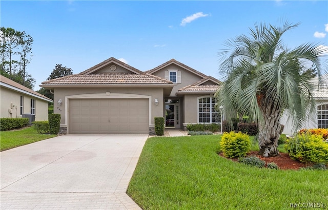 mediterranean / spanish-style house with a garage and a front lawn