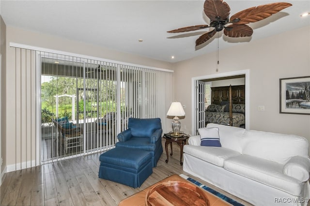 living room featuring ceiling fan and light hardwood / wood-style flooring