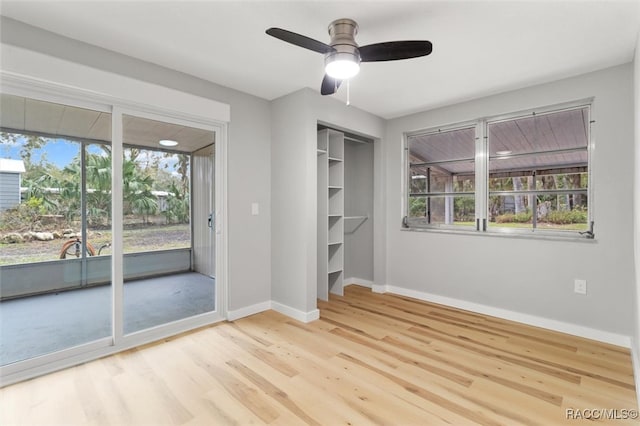 unfurnished bedroom featuring ceiling fan, access to exterior, light wood-type flooring, and a closet