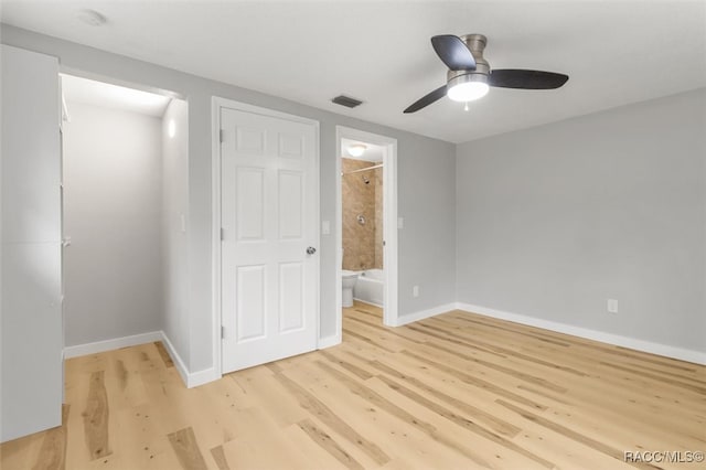 unfurnished bedroom featuring light wood-type flooring, connected bathroom, and ceiling fan