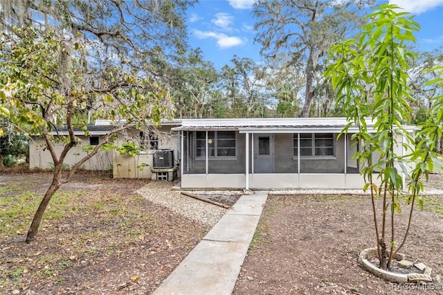 exterior space with a sunroom and central AC unit