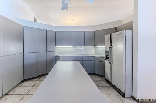 kitchen with light tile patterned floors, gray cabinets, white fridge with ice dispenser, and ceiling fan