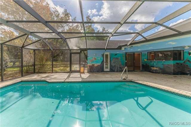 view of pool featuring glass enclosure and a patio area