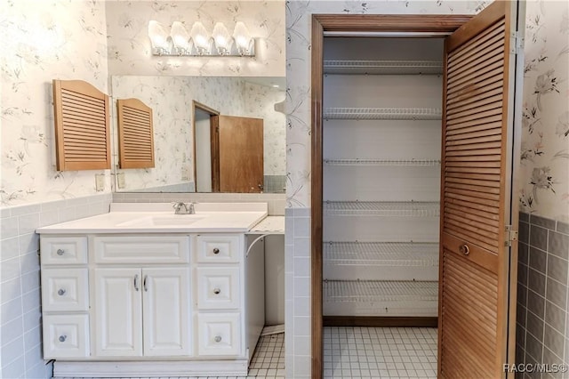 bathroom featuring radiator heating unit, vanity, and tile walls