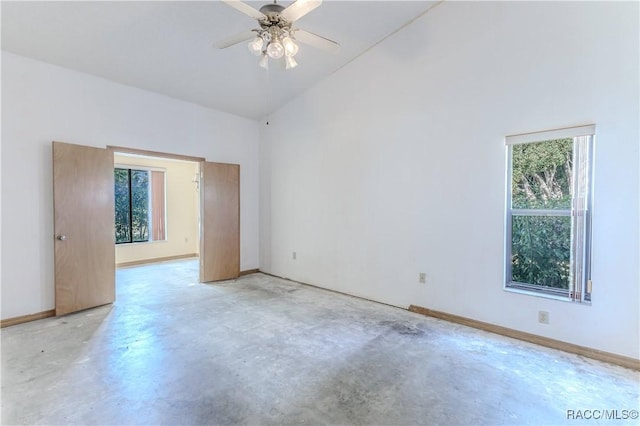 unfurnished room featuring ceiling fan and a high ceiling