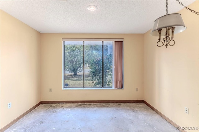 unfurnished room with concrete floors and a textured ceiling