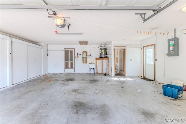 garage featuring electric panel, electric water heater, sink, and a garage door opener