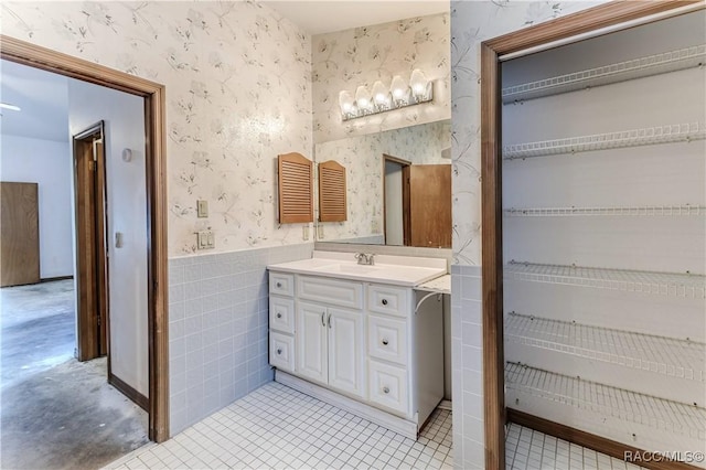 bathroom featuring vanity and tile walls