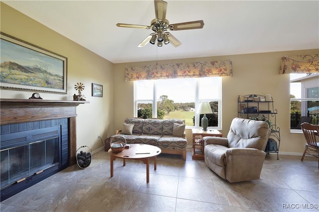 living room with ceiling fan and a tiled fireplace