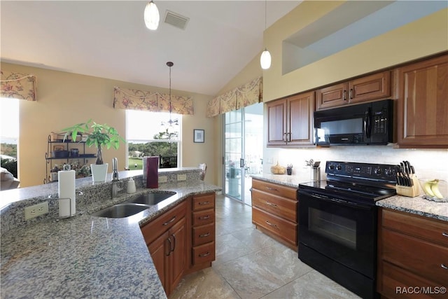 kitchen with light stone counters, sink, black appliances, and decorative light fixtures