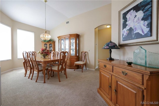 carpeted dining area featuring a chandelier and lofted ceiling