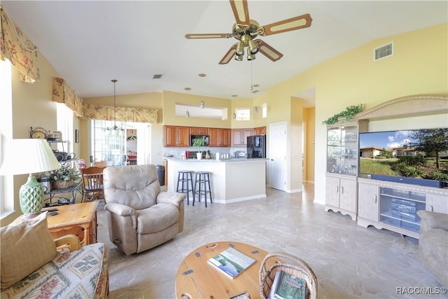 living room featuring ceiling fan with notable chandelier and lofted ceiling