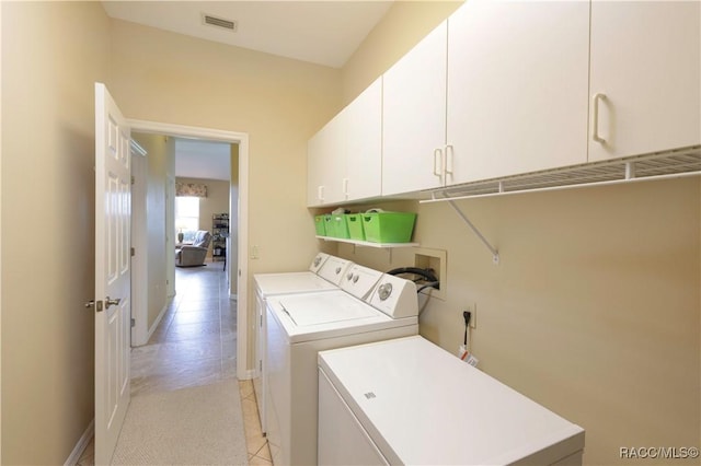 washroom with cabinets and separate washer and dryer