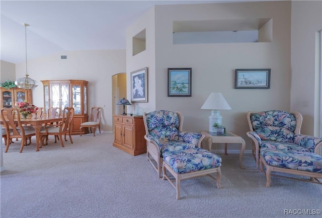 sitting room with light colored carpet and high vaulted ceiling