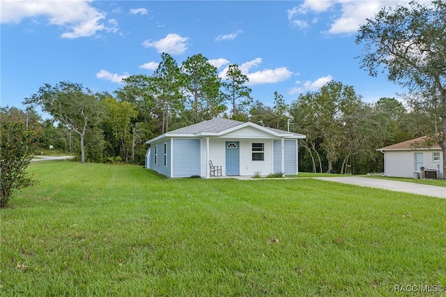 view of outbuilding featuring a yard, covered porch, and central AC unit