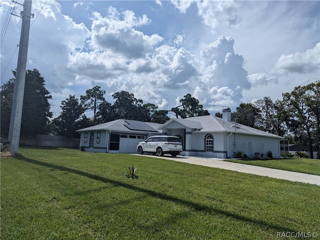 ranch-style home featuring a garage and a front lawn