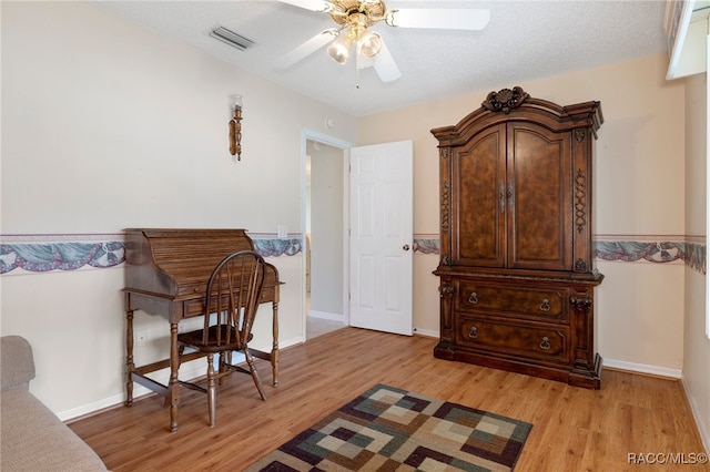 sitting room with a textured ceiling, light hardwood / wood-style flooring, and ceiling fan