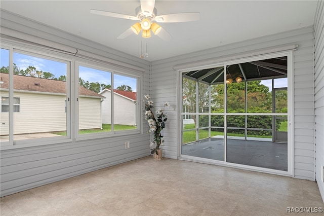 unfurnished sunroom featuring ceiling fan