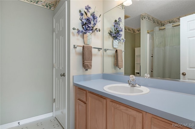 bathroom with a shower with shower curtain, vanity, and a textured ceiling