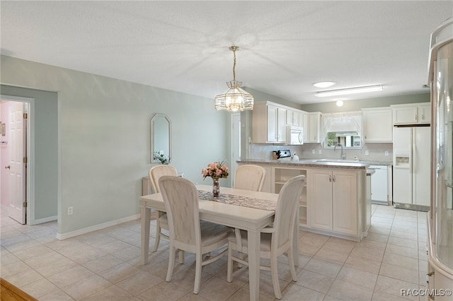 dining space featuring light tile patterned flooring, a textured ceiling, and sink