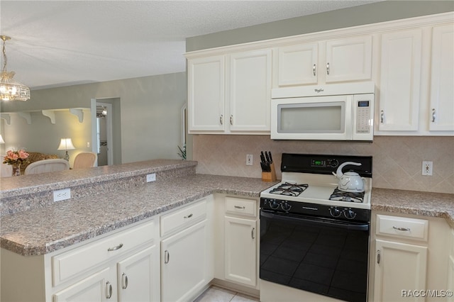 kitchen with backsplash, kitchen peninsula, white cabinets, and white appliances