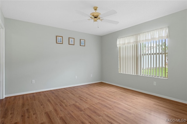 empty room with ceiling fan, a textured ceiling, and light hardwood / wood-style flooring