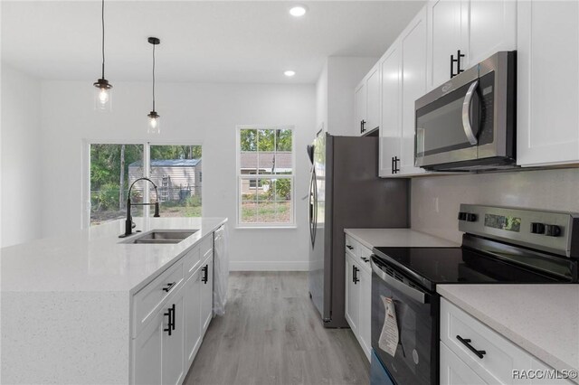 1083 W Cary Dr, Citrus Springs, FL 34434 - kitchen with stainless steel appliances, light wood-style flooring, a sink, recessed lighting, and white cabinetry