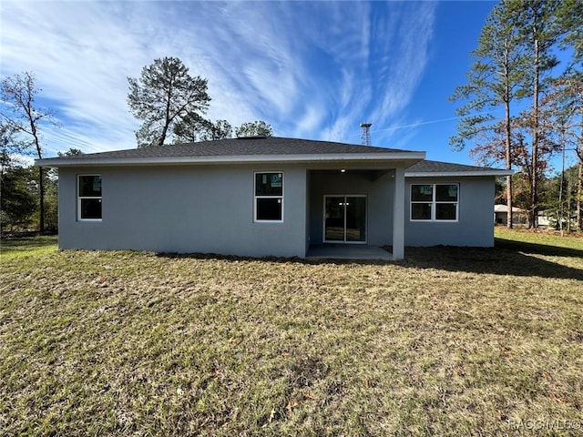 rear view of house with a yard and a patio