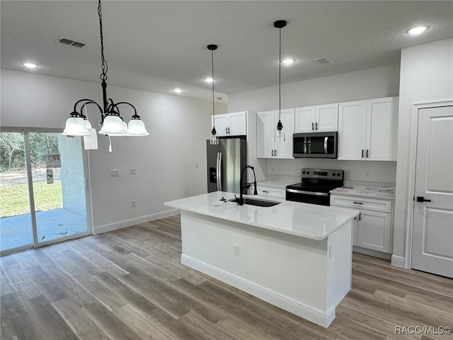 kitchen featuring white cabinetry, sink, appliances with stainless steel finishes, and an island with sink