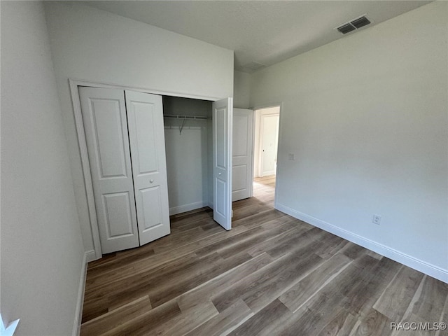 unfurnished bedroom with wood-type flooring and a closet