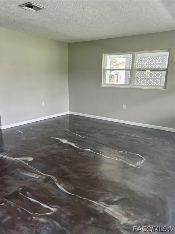 unfurnished room featuring a textured ceiling