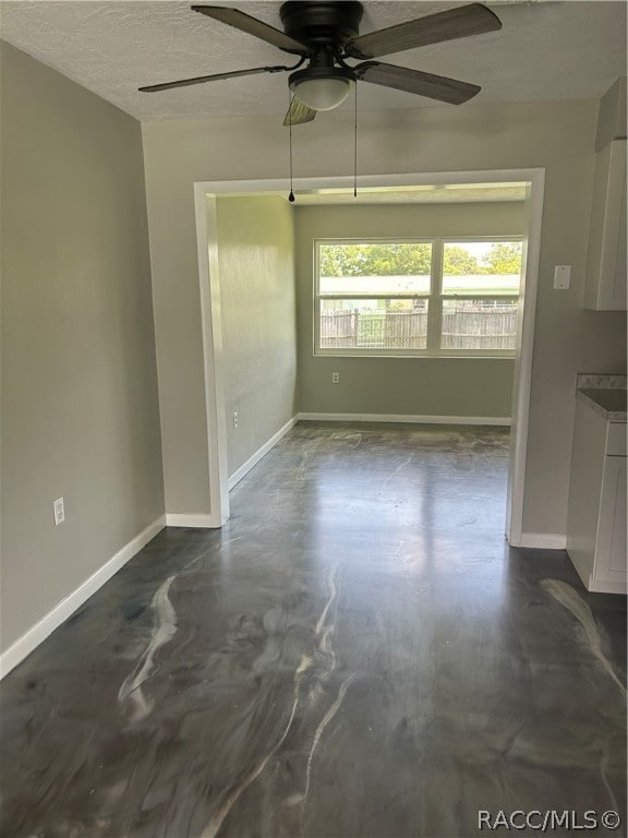 interior space with a textured ceiling and ceiling fan